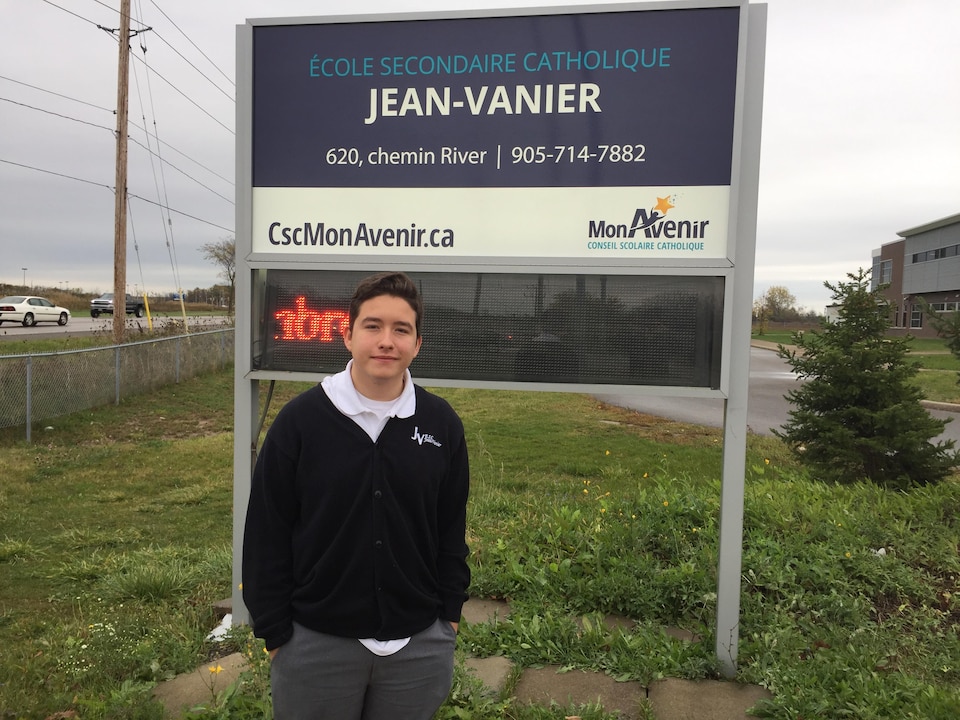 Drew devant le panneau de l'école