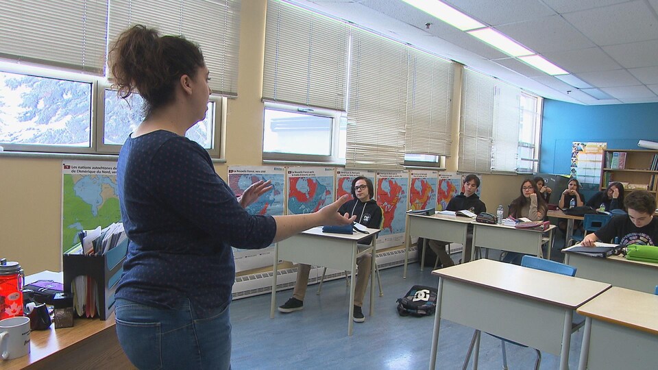 Une enseignante devant une classe remplie d'étudiants.