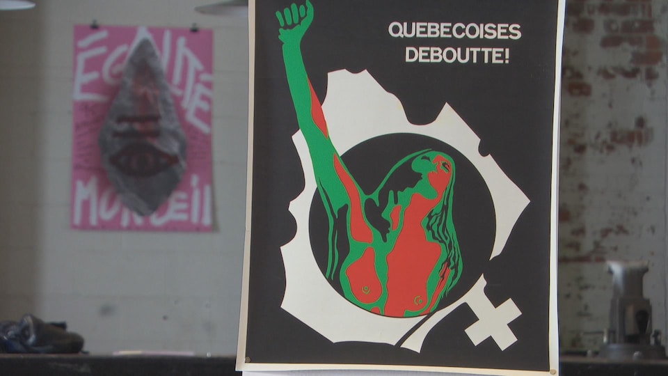 Une affiche sur laquelle est écrit Québécoises deboutte représente une femme le poing levé intégrée dans l'image découpée du territoire de la province.
