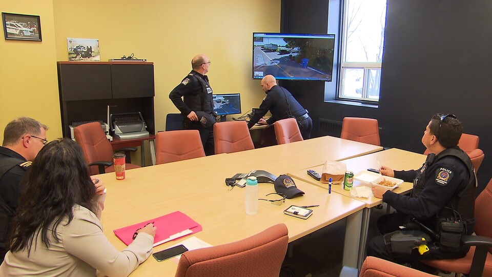 Des policiers autour d'une table dans une salle de réunion.