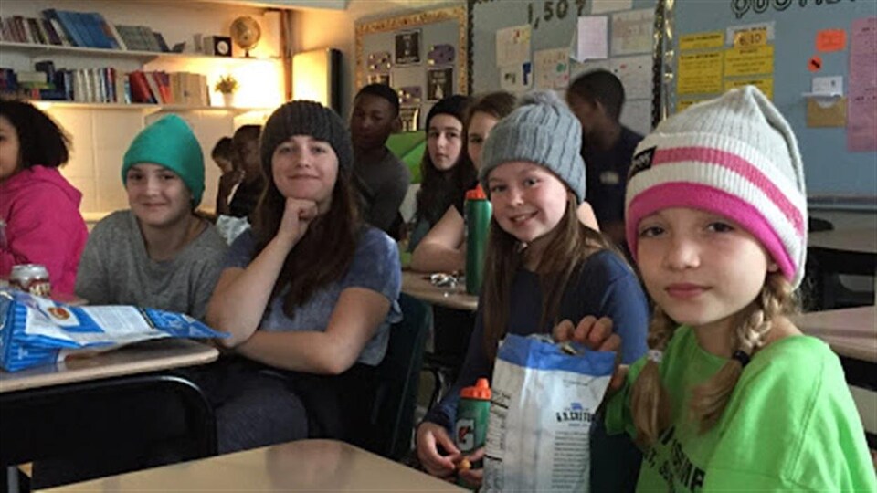 Des élèves de l'École Précieux-Sang portent leurs tuques en visionnant le film La Guerre des tuques.