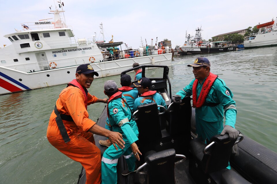 Des membres d'une équipe de secouristes sont à bord d'un bateau et se préparent à aller en mer.