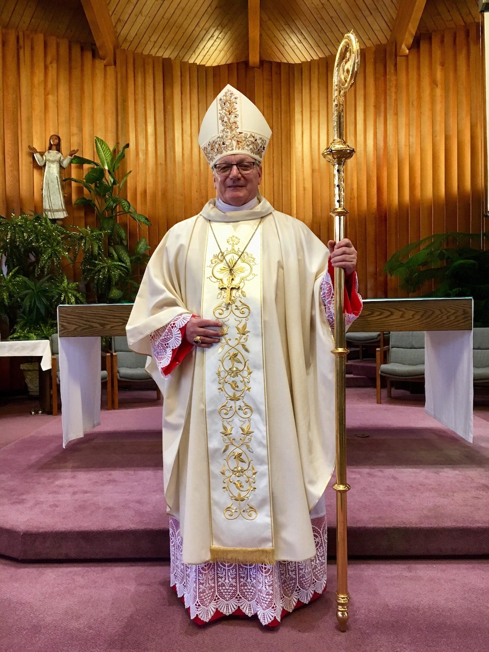 Un évèque devant l'autel d'une église.