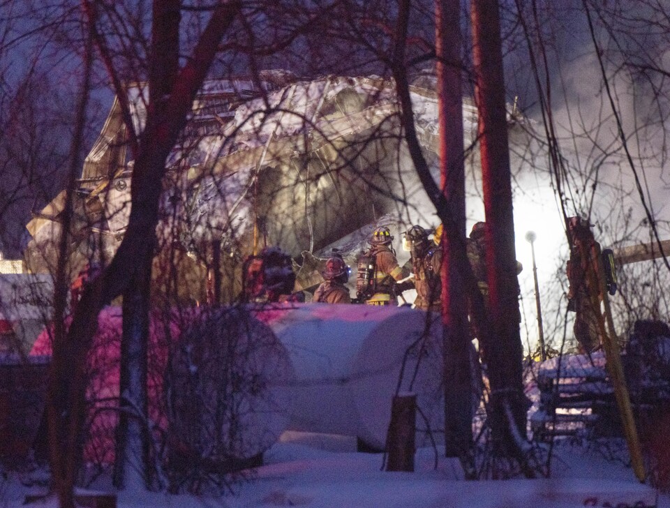 Firefighters at the scene of the fire at dusk.