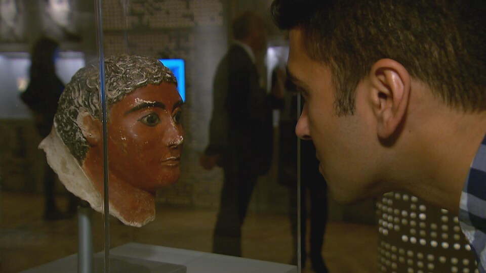 Un homme devant une sculpture de son sosie au Musée de la civilisation