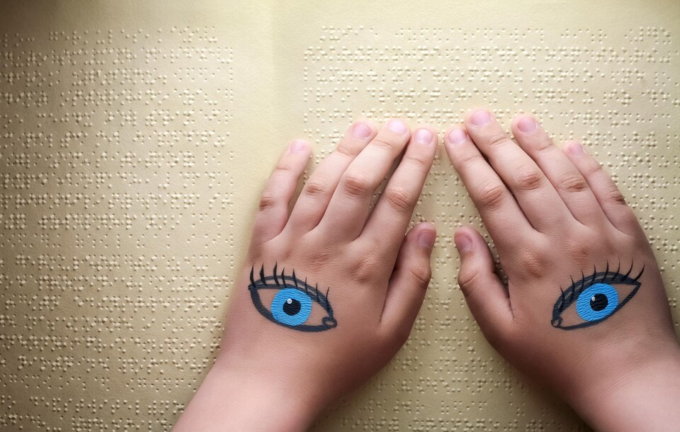 Une personne aveugle qui lit du braille