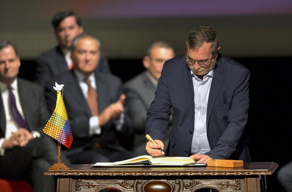 Le chef des Forces armées révolutionnaires de Colombie (FARC), Timoleon Jimenez, ratifie l'accord de paix après le président du pays, Juan Manuel Santos, à Bogota, le 24 novembre 2016.