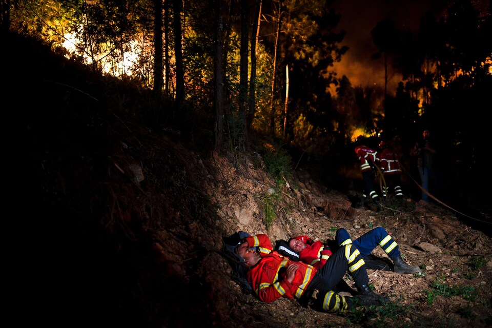 Des pompiers prennent une pause alors qu'ils combattent le violent incendie de forêt au Portugal.