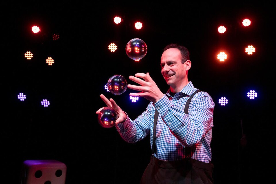Un homme jongle avec des bulles.