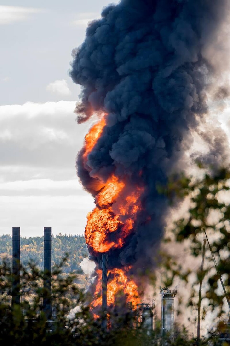 Une gerbe de flammes s'échappe de la raffinerie.