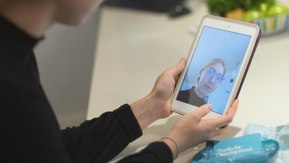 Elle regarde une photo d'elle sur un iPad.