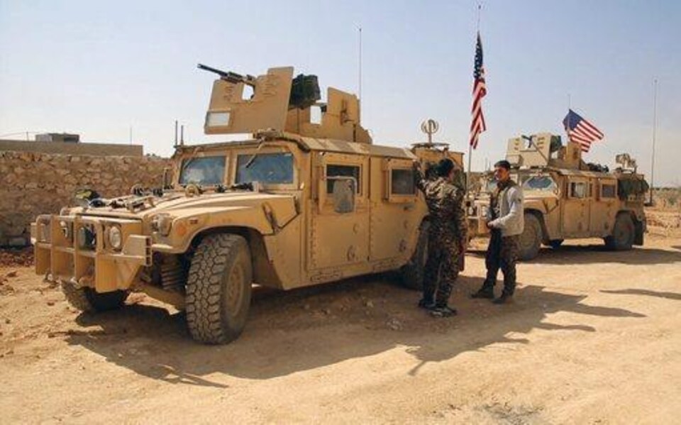 Des combattants des Forces démocratiques syriennes (FDS) près de véhicules militaires américains aux abords de Manbij, dans la province d’Alep, en Syrie, le 7 mars 2017, soit deux mois avant l’offensive menée à Raqqa.
