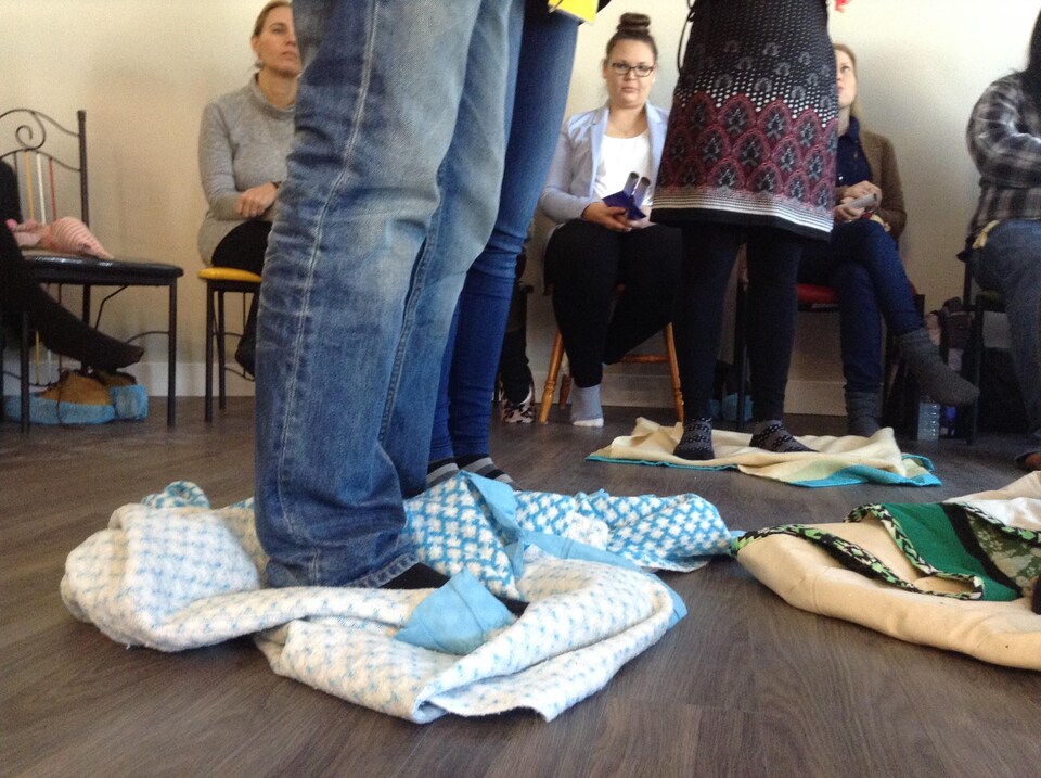 Les couvertures sur lesquelles se tiennent les participants sont repliées sur leurs pieds, leur laissant de moins en moins d'espace pour se tenir debout.