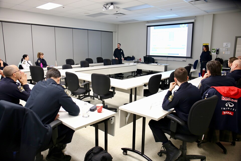 Des policiers suivent une formation dans une salle.