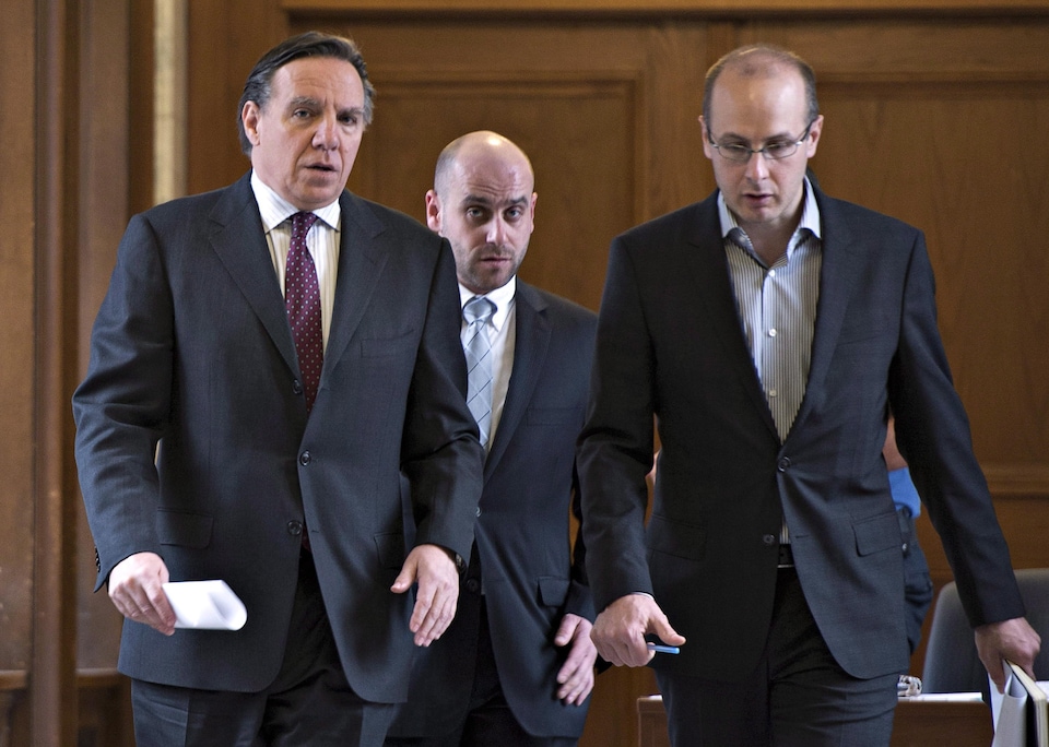 François Legault, Jean-François Del Torchio et Martin Koskinen marchent dans un corridor.