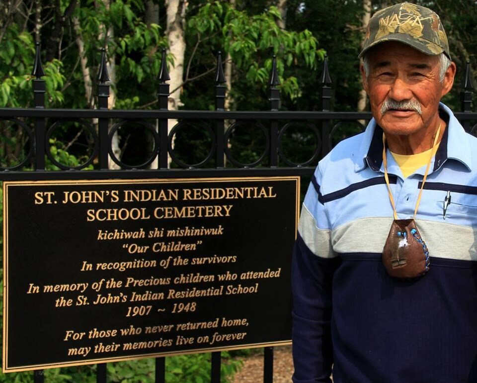Fred Neegan pose devant le pensionnat indien de St. John