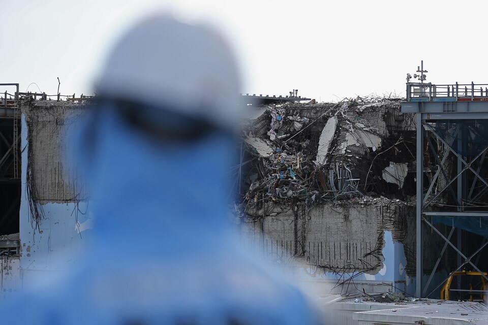Un employé travaillant à la décontamination du site observe un des réacteurs qui avaient été détruits. 