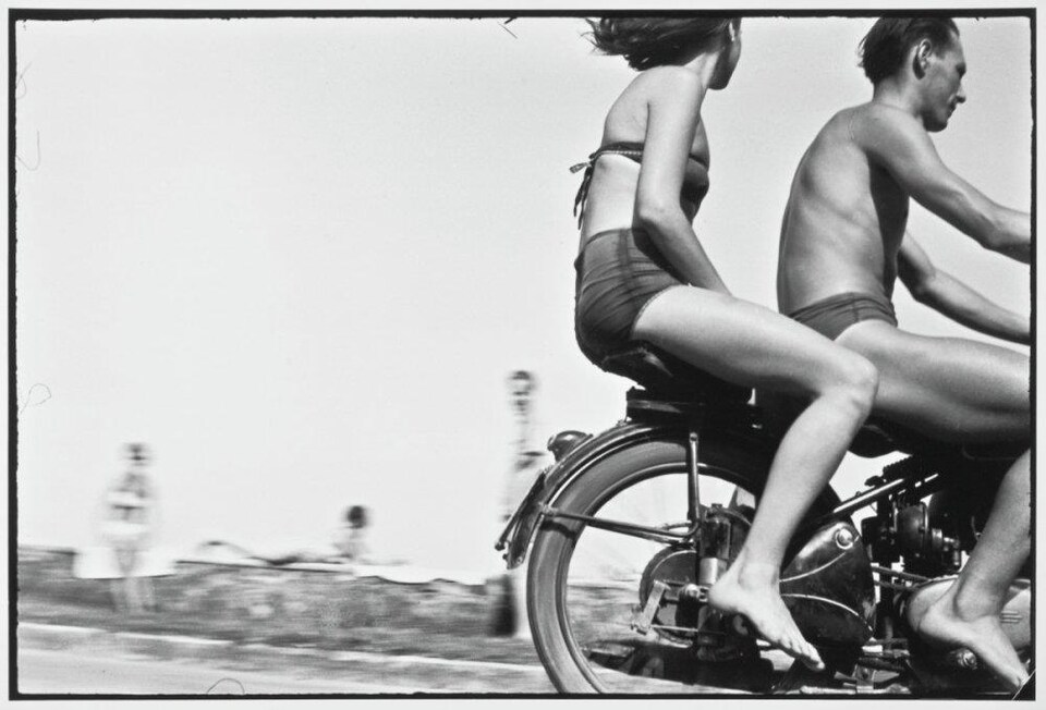 Un homme et une femme sont sur une motocyclette en marche. 