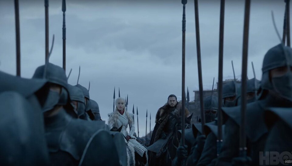 Daenerys et Jon Snow sont sur des chevaux, entourés de soldats à pied. 