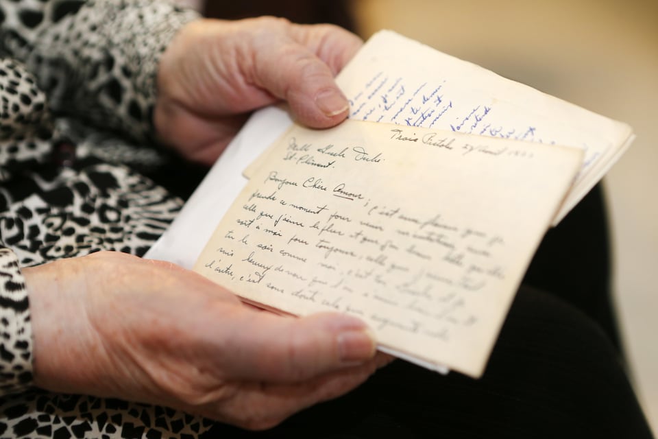 Gisèle Dubé Bélanger tient dans ses mains les lettres de son défunt mari. 