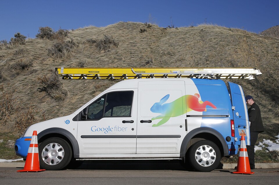 Un technicien de Google Fiber en train de prendre du matériel dans sa camionnette.