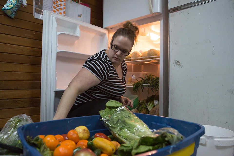 Jessica Saulnier place les aliments dans un frigo.