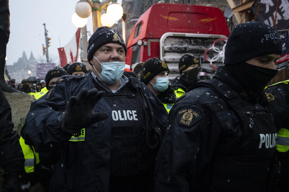 Des agents de la GRC intervenant sous la neige pendant l'occupation du centre-ville d'Ottawa.