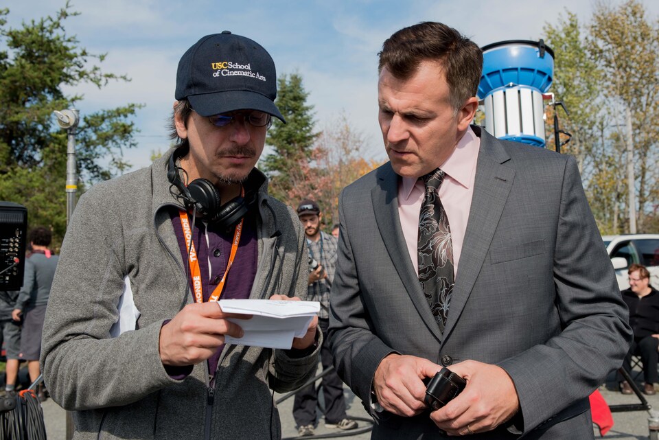 À gauche, le réalisateur Philippe Falardeau et, à droite, l'acteur Patrick Huard sont debout côte à côte lors du tournage du film « Guibord s’en va-t-en guerre ».