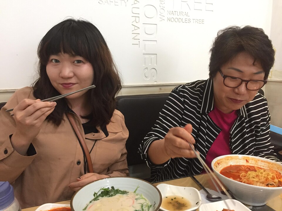 Deux femmes d'origine coréenne mangent des nouilles.