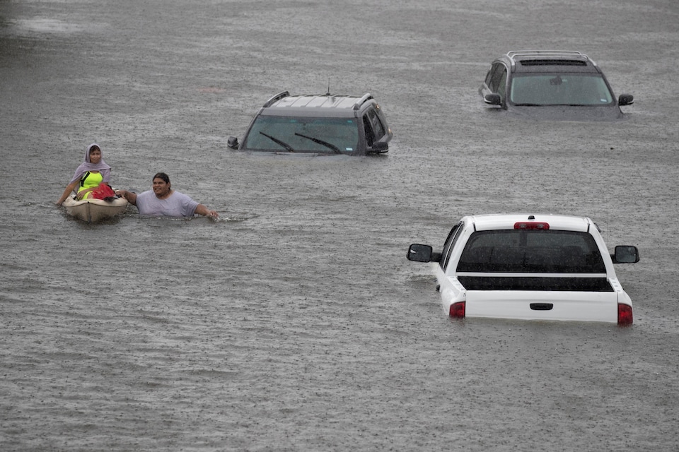 Jesus Rodriguez vient en aide à Gloria Garcia, résidente de Pearland en banlieue de Houston durement touchée par l'ouragan Harvey.