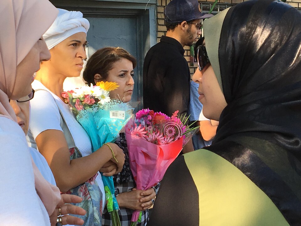 Des femmes voilées tiennent des bouquets de fleurs, en attente de la cérémonie à la mémoire de la cycliste morte le 14 juillet.
