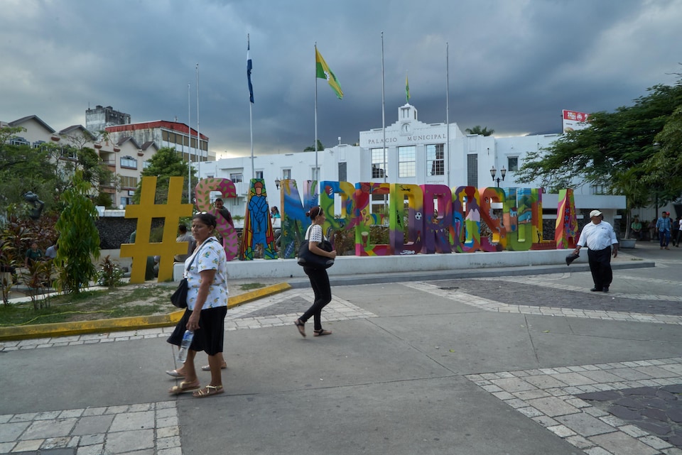 Des gens marchent dans la rue à San Pedro Sula, au Honduras.           