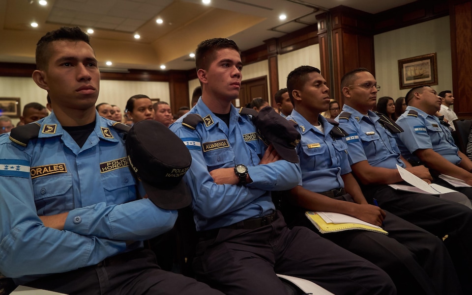 Des policiers assis dans une salle, au Honduras.