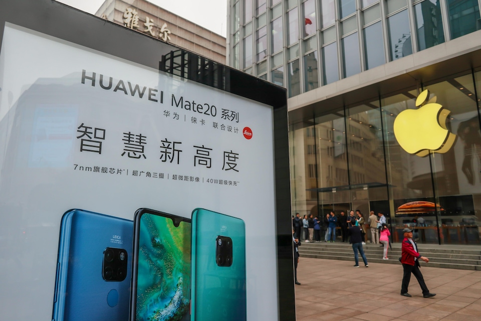 Un panneau publicitaire de Huawei est visible devant un magasin Apple dans une rue de Shanghai.