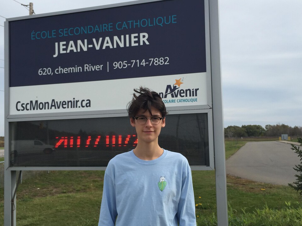 Photo d'Ilann devant le panneau de l'école