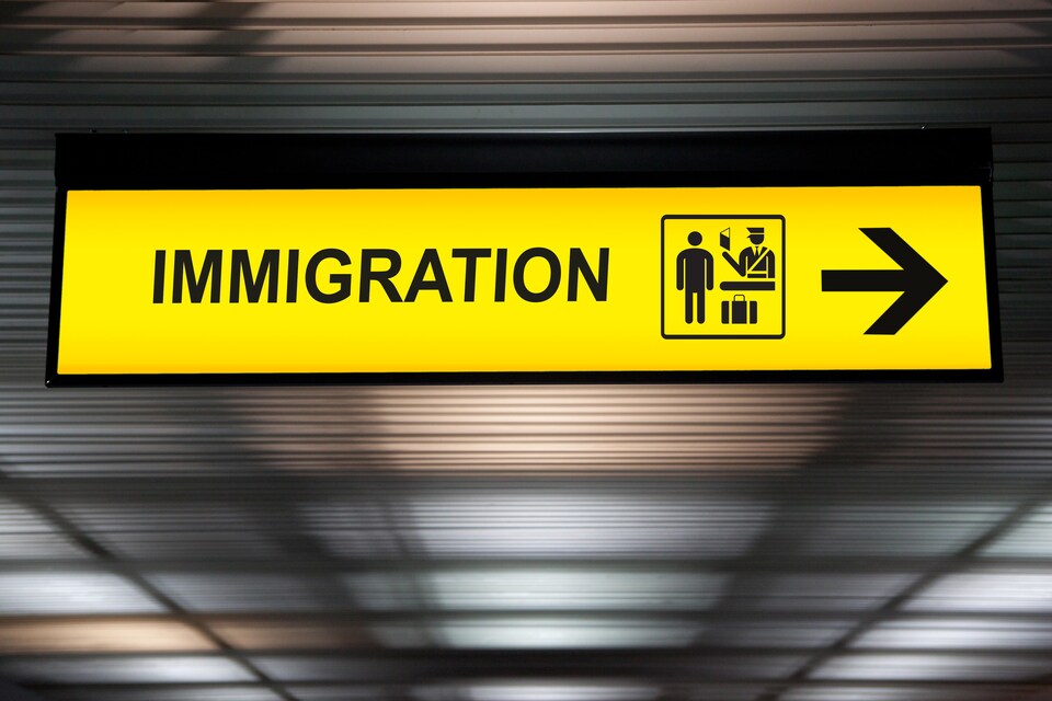 Un panneau signalétique montrant les douanes pour les passagers en immigration dans un aéroport. 
