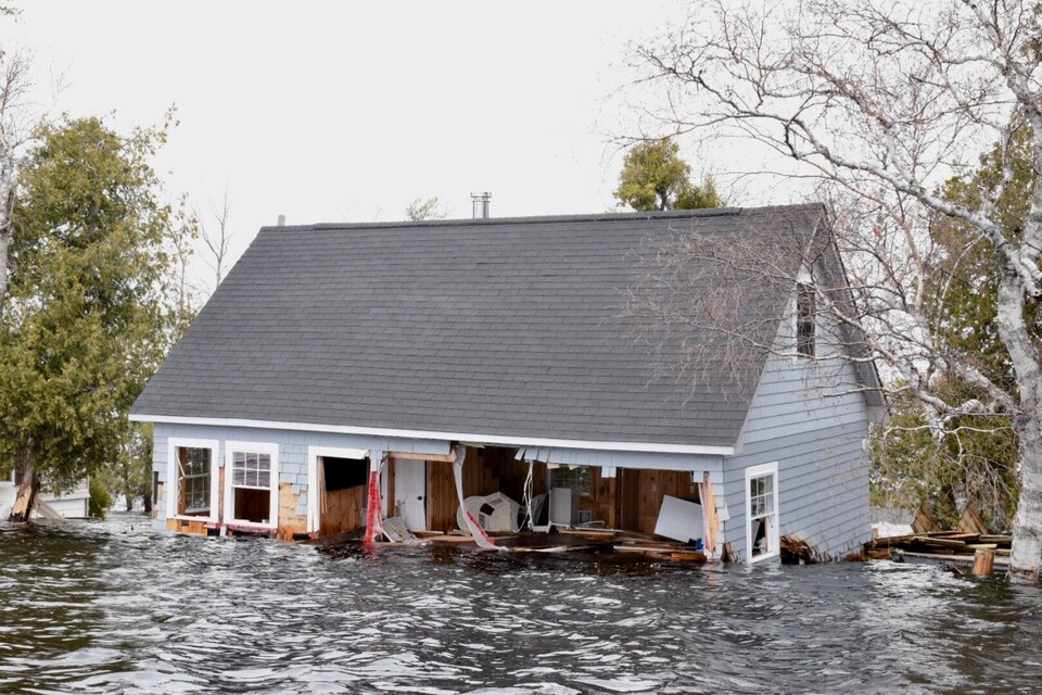 Une partie d'un mur d'une maison inondée est arraché à Princess Park, dans la région de Grand Lake au Nouveau-Brunswick, le 28 avril 2019.