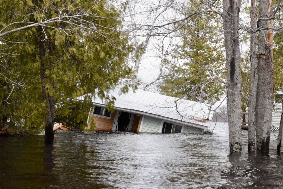 Habitation emportée par les inondations et submergée sur le côté à Princess Park, dans la région de Grand Lake au Nouveau-Brunswick, le 28 avril 2019.