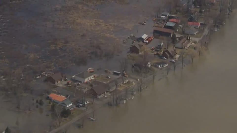 Vue aérienne de maisons près d'une rivière qui déborde. 