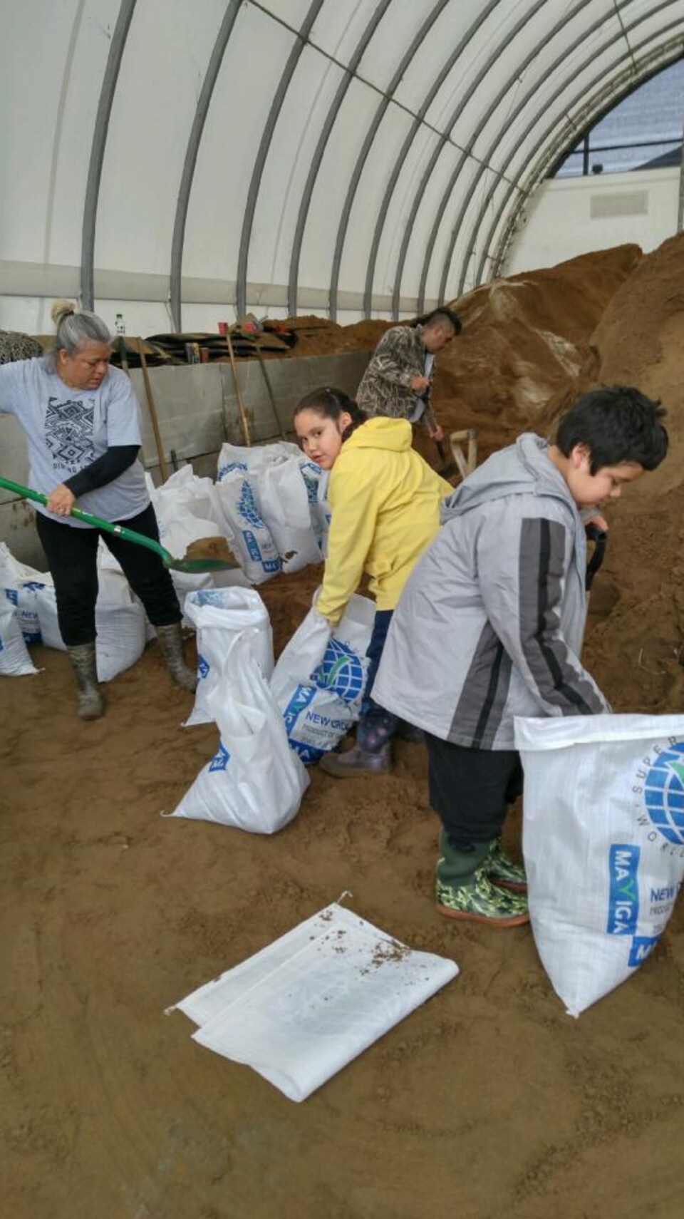 Les enfants de Nicole Gagnier remplissent des sacs de sable
