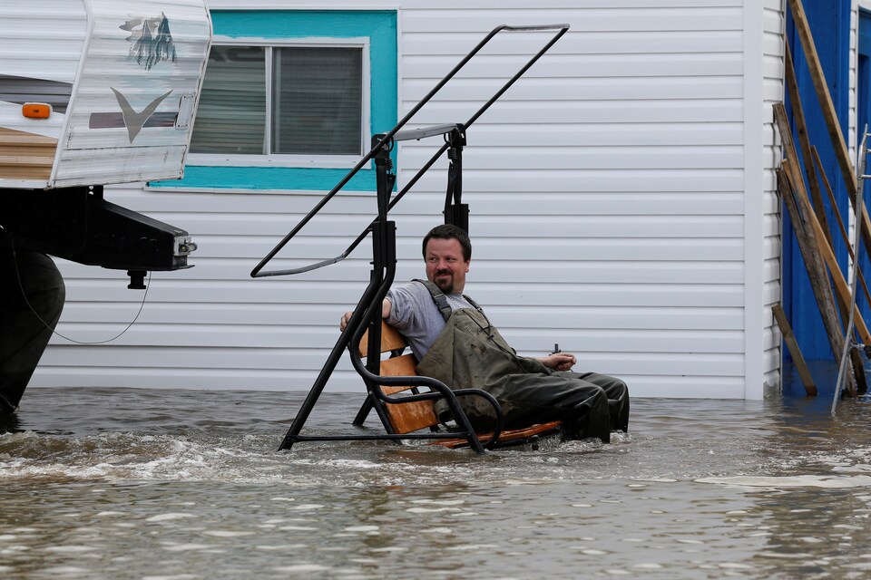 Un résident de Rigaud observe les effets de l'inondation dans sa balançoire.