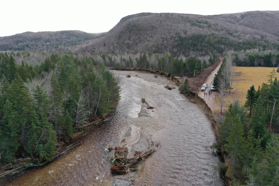 Photo aérienne d'une route brisée qui se termine dans la rivière.