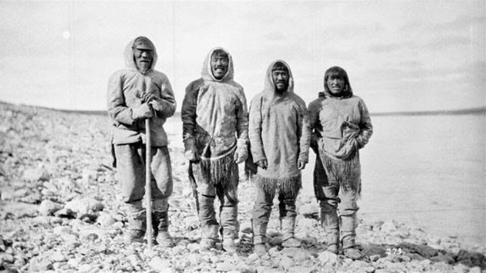 Ces quatre Inuits, debout près du rivage à Baker Lake (Qamanittuaq), au Nunavut, n’ont toujours pas été identifiés.