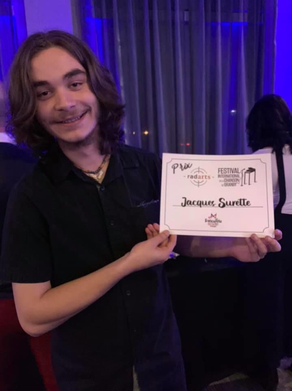 Jacques surette tenant un certificat sur lequel est écrit son nom. 