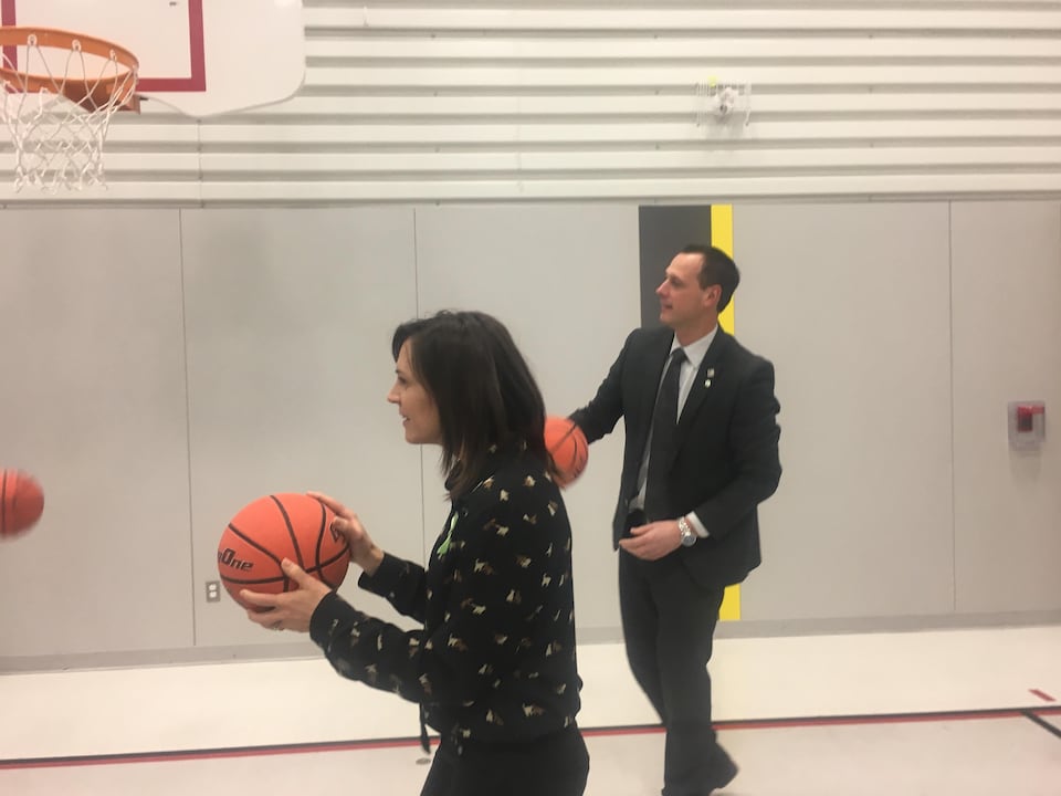Jean-François Roberge et Isabelle Charest ont un ballon de basketball dans les mains dans un gymnase.