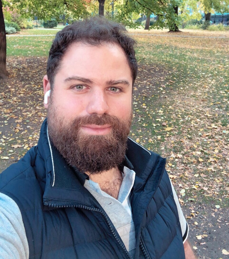 Un homme barbu prend un egoportrait dans un parc