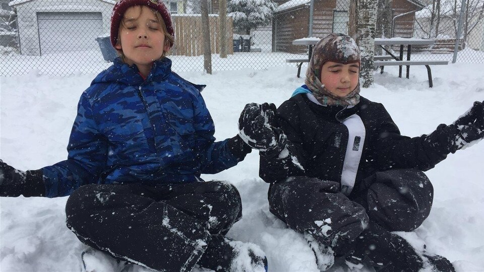 Des enfants assis dans la neige