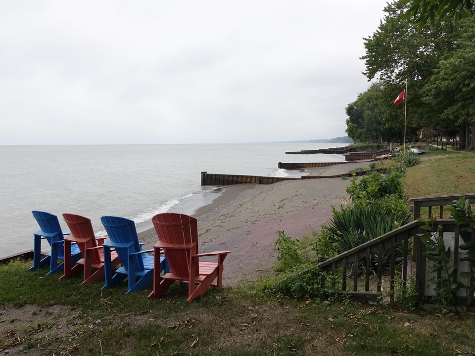 On voit des chaises alignées près d'une plage du lac Érié.