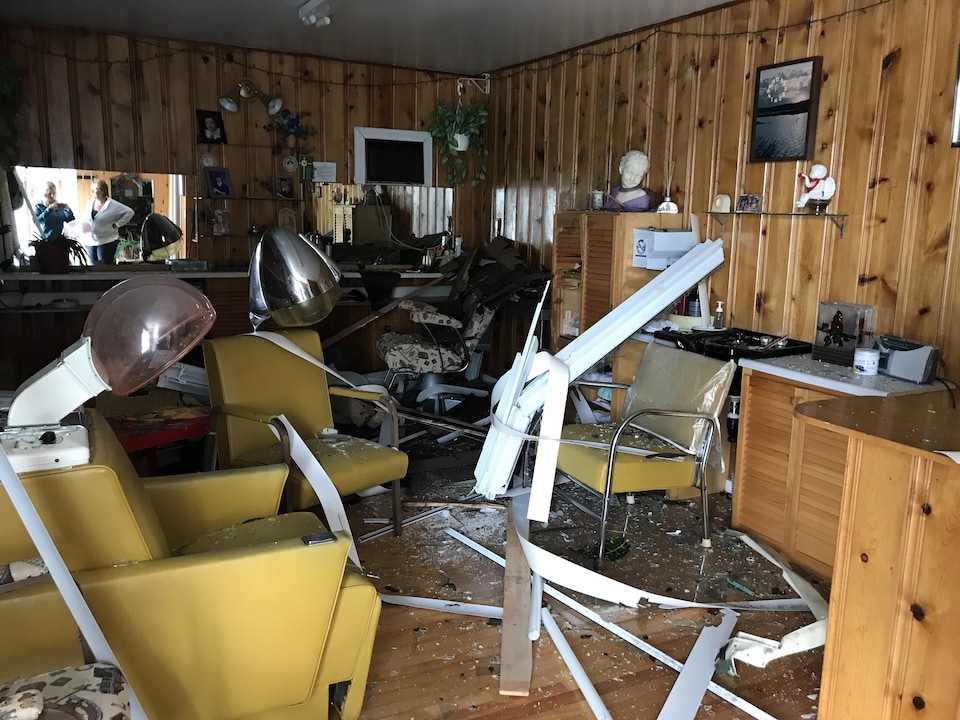 Cette résidence de Lachute est considérée comme inhabitable à la suite du passage de la tornade qui a lourdement endommagé la toiture. Des débris recouvrent le sol de ce qui semble être une salle de salon de coiffure.
