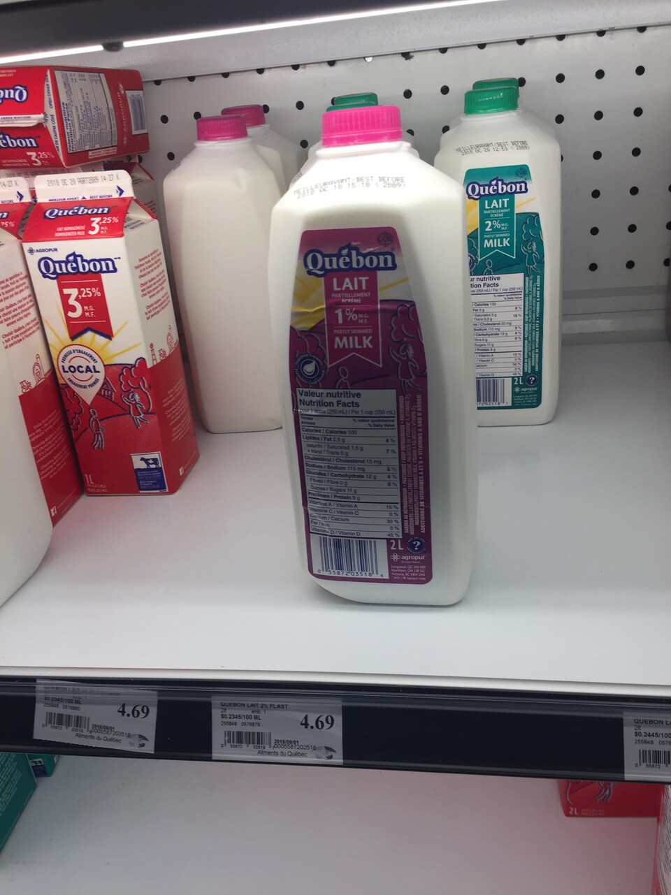 Il y a deux contenants de lait sur une étagère.